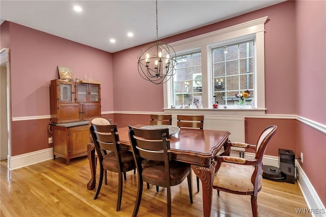 dining area with radiator, light wood finished floors, recessed lighting, a notable chandelier, and baseboards