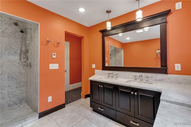 full bath featuring tile patterned flooring, double vanity, a sink, and tiled shower