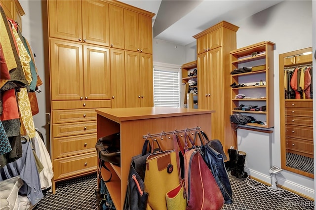 walk in closet featuring dark colored carpet