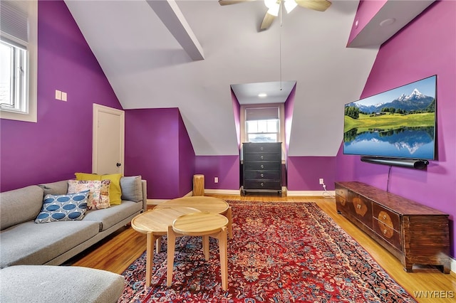 living room featuring wood finished floors, a ceiling fan, high vaulted ceiling, and baseboards