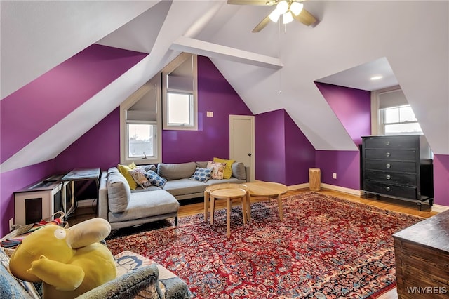 living room with wood finished floors, a healthy amount of sunlight, and vaulted ceiling