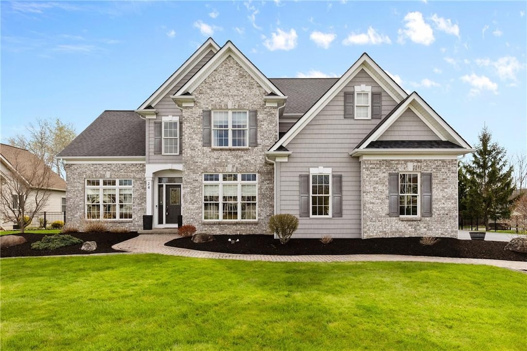 craftsman-style home featuring a front lawn and brick siding