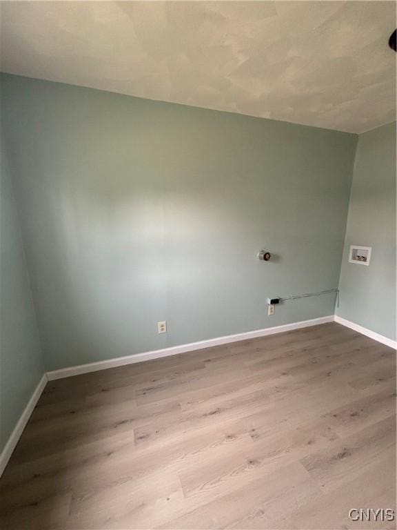 washroom with baseboards, wood finished floors, and laundry area