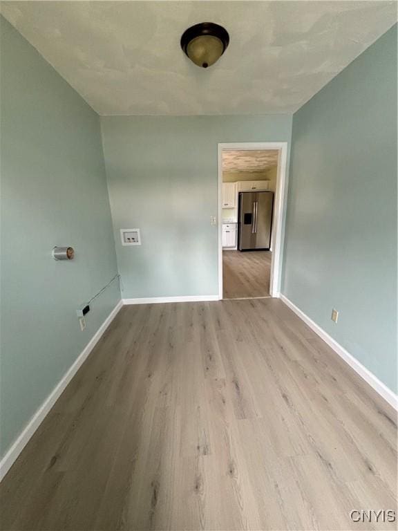 spare room with wood finished floors and baseboards