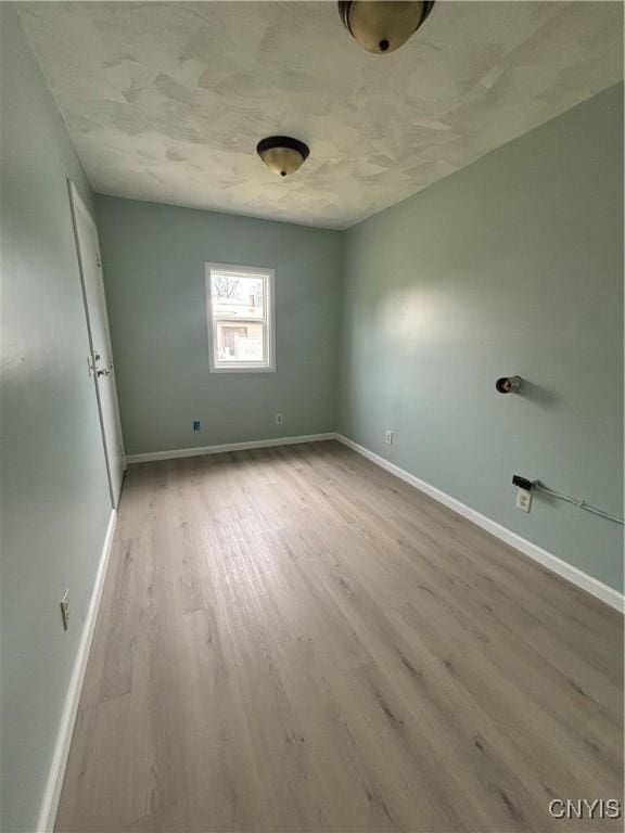 empty room featuring wood finished floors and baseboards