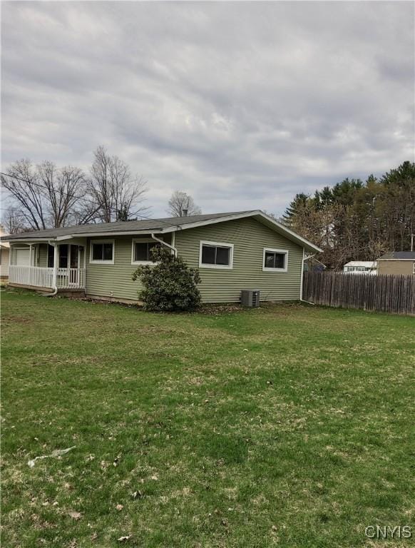 rear view of property with central AC, fence, a porch, and a lawn