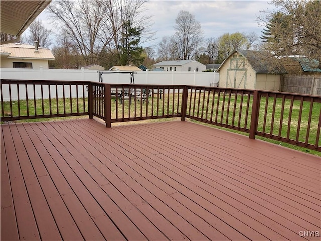 wooden terrace with a storage unit, a fenced backyard, and an outdoor structure