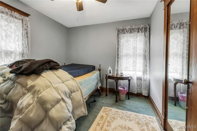 carpeted bedroom with baseboards, a ceiling fan, and a textured ceiling