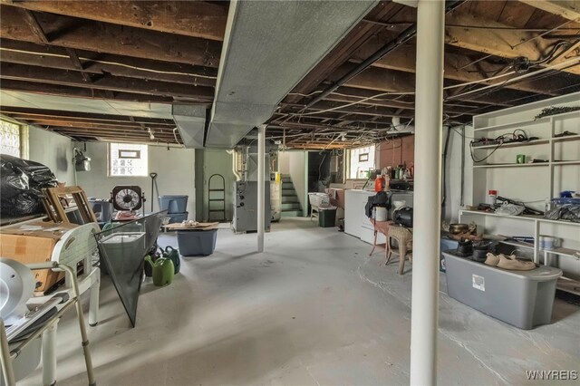 below grade area featuring heating unit, stairs, and washer / clothes dryer