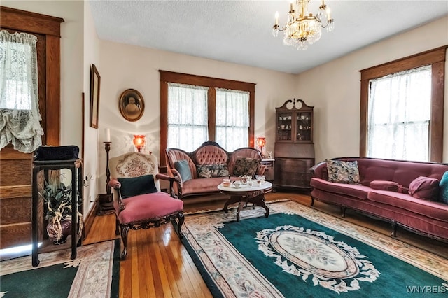 living room featuring an inviting chandelier, a wealth of natural light, and hardwood / wood-style flooring