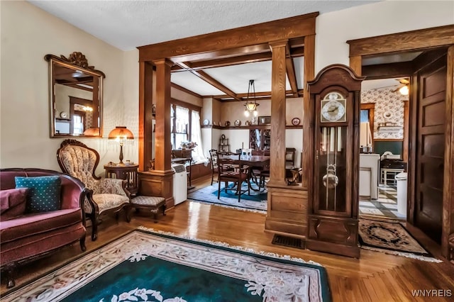 sitting room with wood finished floors and decorative columns