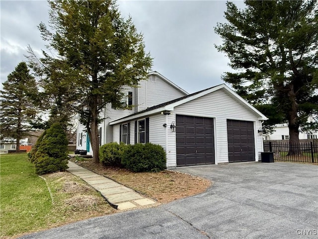 view of side of property featuring fence and an attached garage