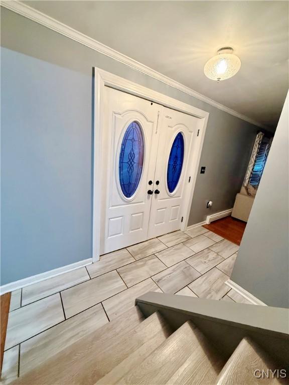 entryway featuring ornamental molding and baseboards