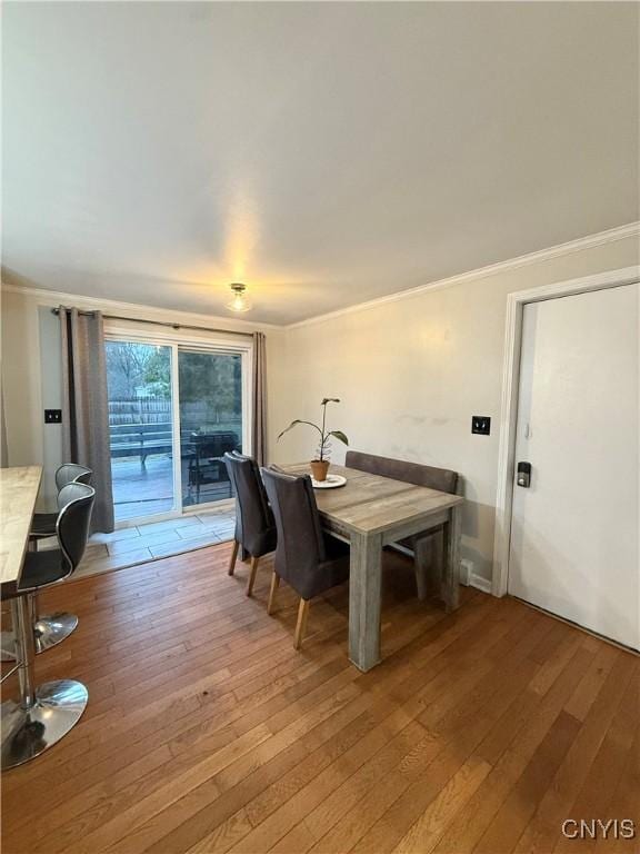dining room featuring ornamental molding and light wood-style flooring