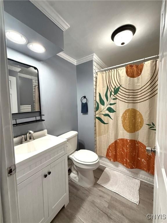 full bathroom with curtained shower, crown molding, toilet, wood finished floors, and vanity