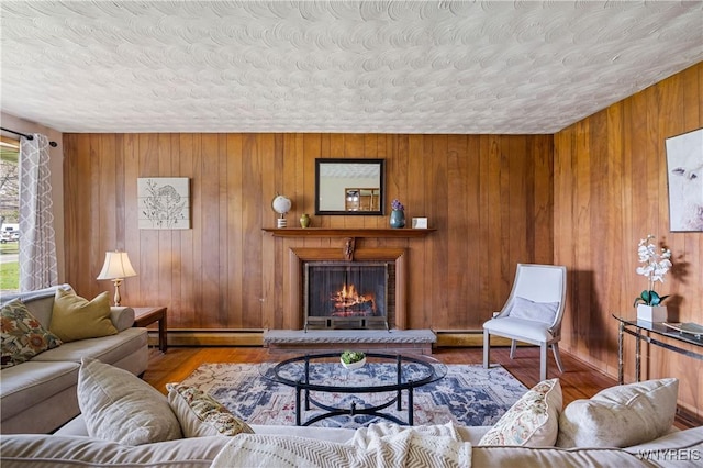 1631 Tuscarora Rd, Niagara, NY 14304 - living room featuring a baseboard heating unit, wood finished floors, wood walls, and a lit fireplace