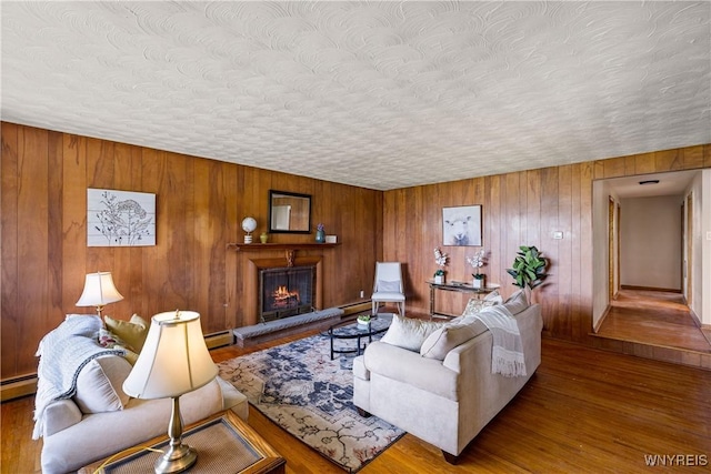 1631 Tuscarora Rd, Niagara, NY 14304 - living area with wood finished floors, a textured ceiling, a warm lit fireplace, and a baseboard radiator