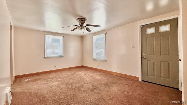 carpeted spare room with baseboards and a ceiling fan