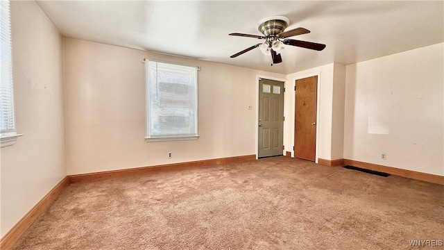 unfurnished room with a ceiling fan, baseboards, and carpet floors