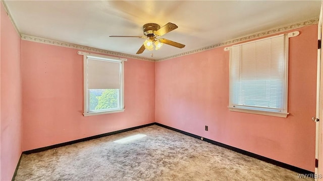 carpeted spare room featuring a ceiling fan and baseboards