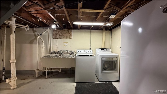 laundry area featuring a sink, laundry area, and washer and clothes dryer