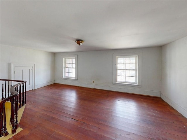 empty room featuring baseboards and wood-type flooring