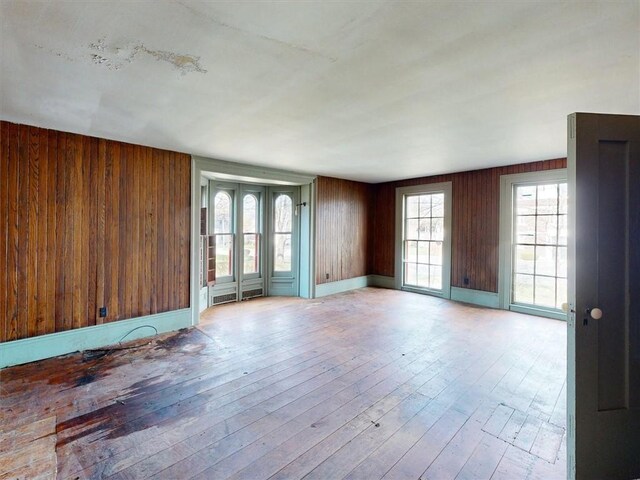 empty room with wooden walls and wood-type flooring