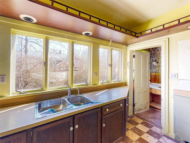 kitchen with light floors, light countertops, plenty of natural light, and a sink