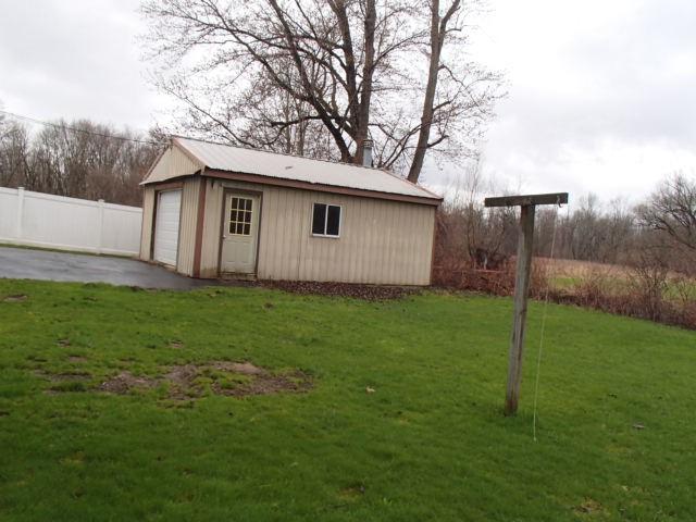 view of outdoor structure featuring fence and an outdoor structure