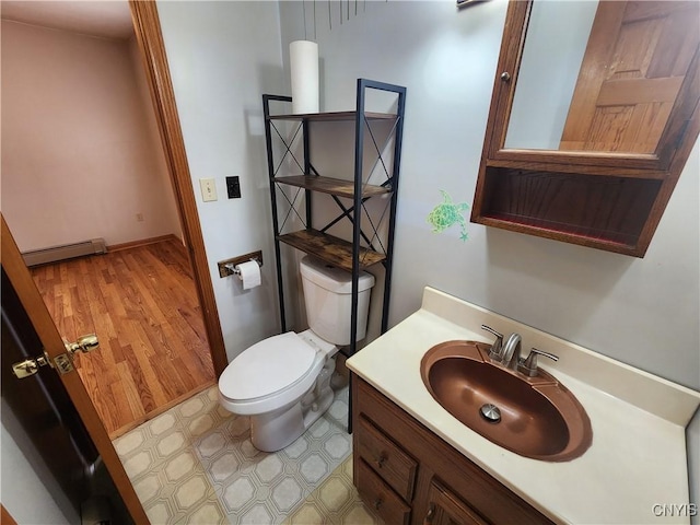 bathroom featuring vanity, toilet, and a baseboard heating unit