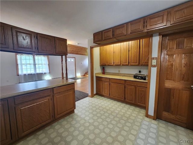kitchen with light countertops, brown cabinetry, and light floors