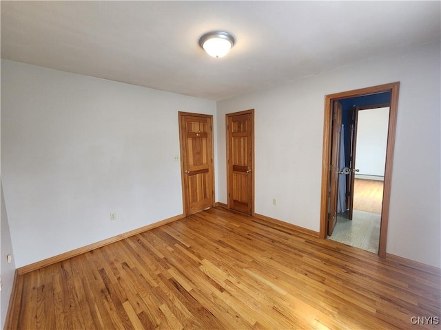 empty room with light wood-style floors and baseboards