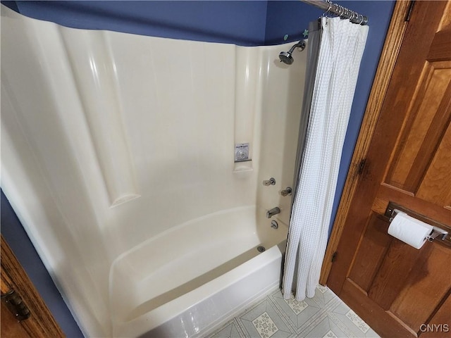 bathroom with shower / bath combo with shower curtain and tile patterned flooring
