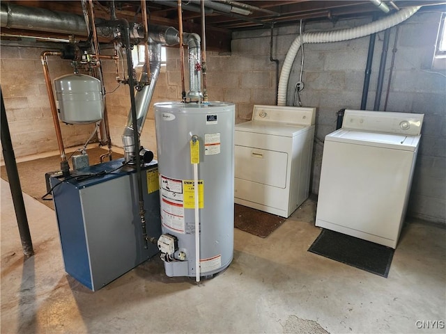 utility room featuring gas water heater, washer and clothes dryer, and a heating unit