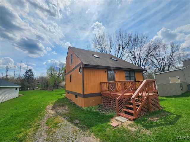 rear view of house featuring a lawn, a wooden deck, crawl space, and a shingled roof