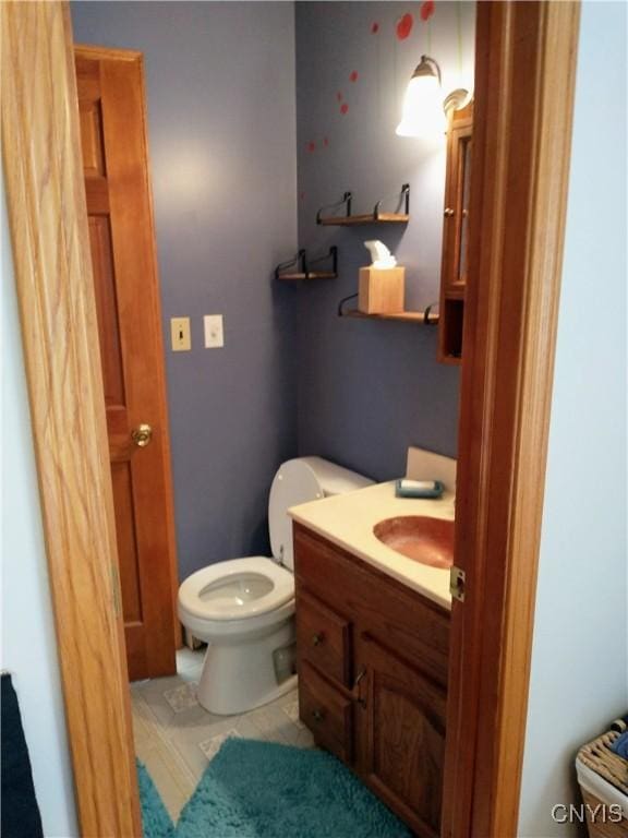 half bathroom with vanity and toilet