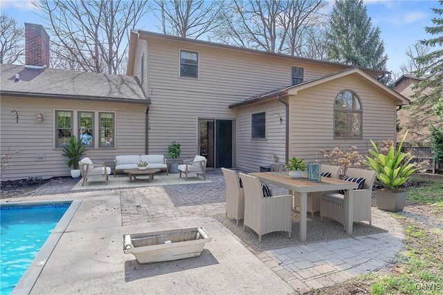 7266 Wakefield Dr, Manlius, NY 13066 - rear view of property featuring outdoor dining area, a patio area, an outdoor living space, an outdoor pool, and a chimney