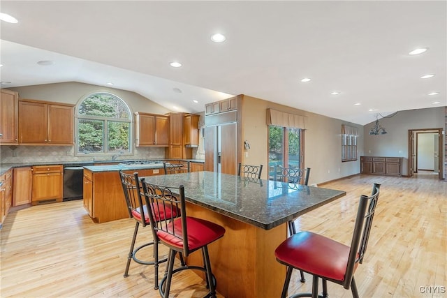7266 Wakefield Dr, Manlius, NY 13066 - kitchen with lofted ceiling, decorative backsplash, a center island, dishwashing machine, and light wood-type flooring