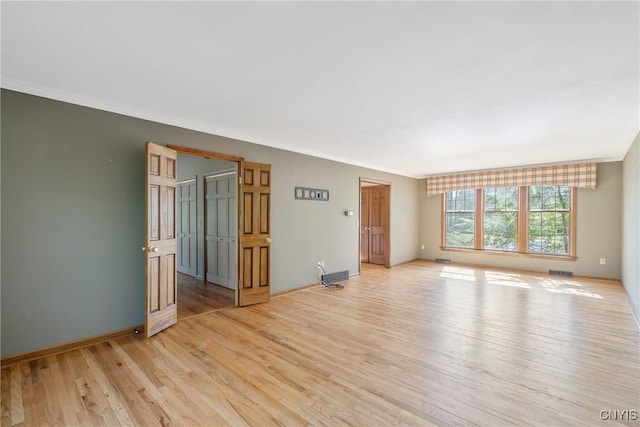 7266 Wakefield Dr, Manlius, NY 13066 - spare room featuring baseboards, light wood-type flooring, ornamental molding, and visible vents