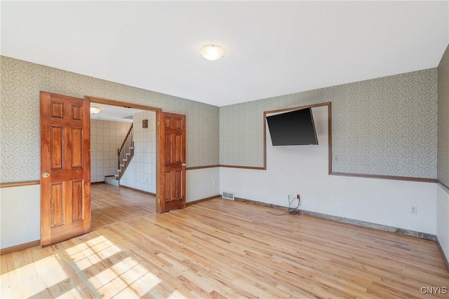 7266 Wakefield Dr, Manlius, NY 13066 - empty room with light wood-style flooring, stairway, visible vents, wallpapered walls, and baseboards