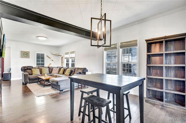 dining area with crown molding, baseboards, a notable chandelier, and wood finished floors
