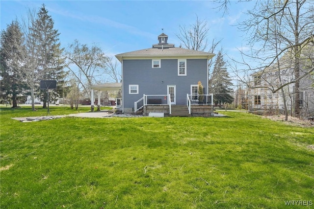 back of property featuring a lawn, an attached carport, and a deck