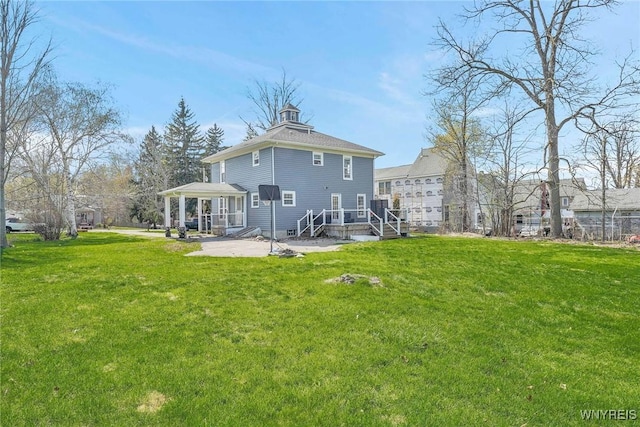 rear view of house featuring a lawn and a patio area