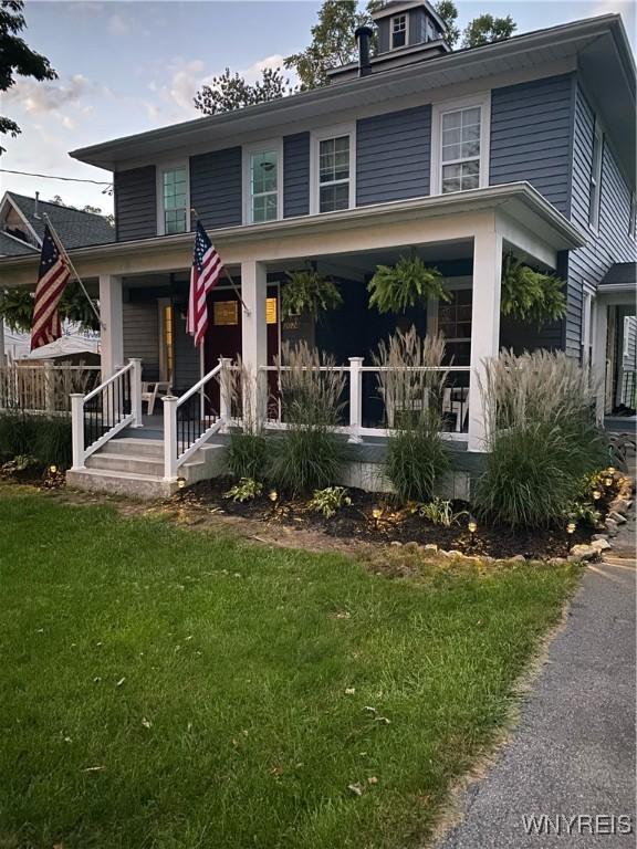 traditional style home featuring a porch and a front lawn