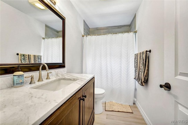 full bath featuring vanity, toilet, a shower with shower curtain, baseboards, and wood finished floors