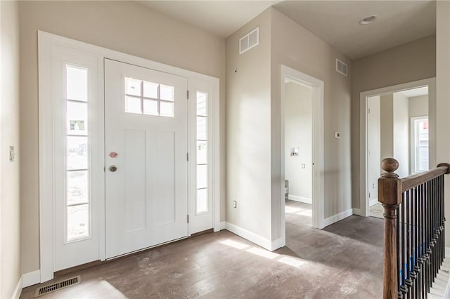 entryway featuring visible vents, baseboards, and wood finished floors