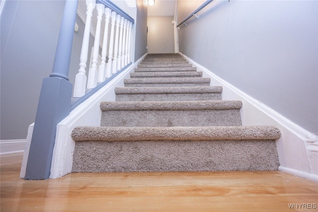 stairs featuring wood finished floors and baseboards