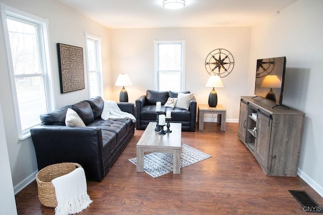living room featuring visible vents, dark wood finished floors, and baseboards