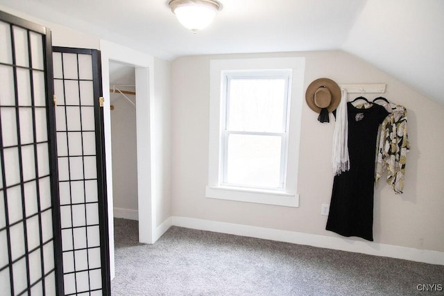 interior space with baseboards, lofted ceiling, carpet, and plenty of natural light