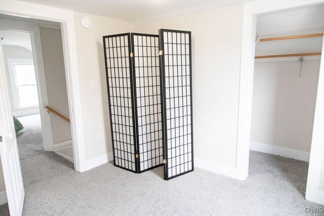 unfurnished bedroom featuring a closet, carpet, and baseboards